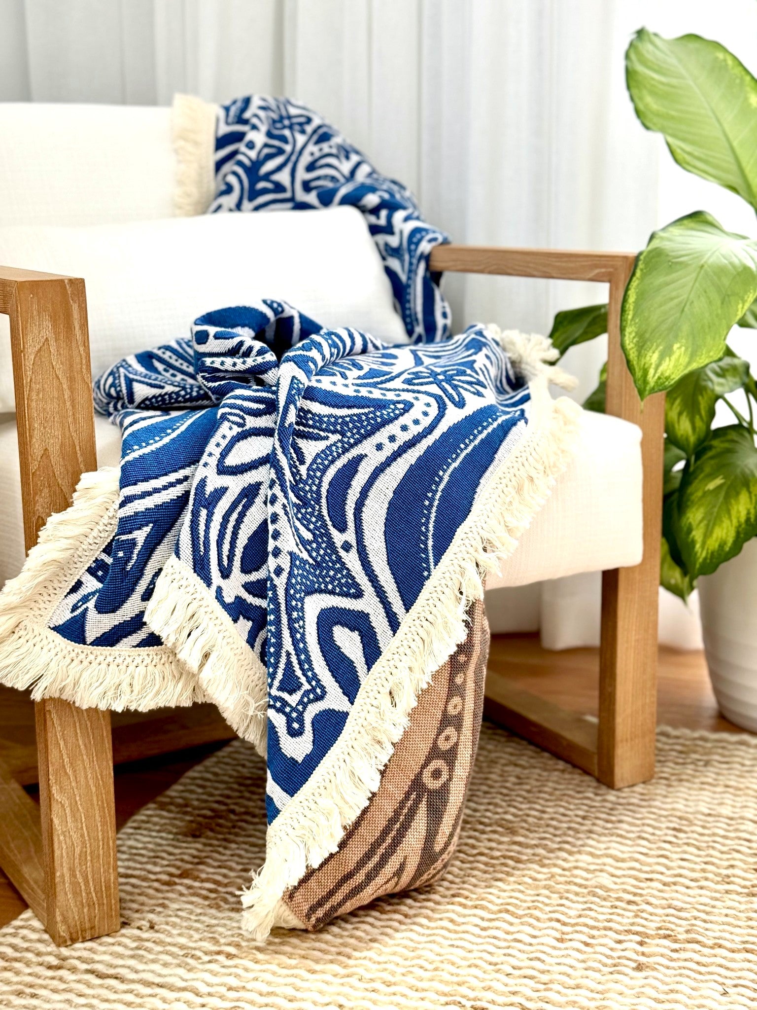 Blue Skies beach blanket, picnic rug or throw rug draped over arm of occasional chair. Designed in Australia. 