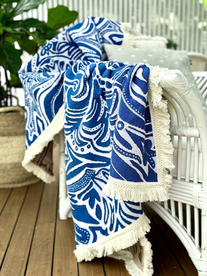 Blue Skies beach blanket, picnic rug or throw rug draped over arm of chair. Designed in Australia. 