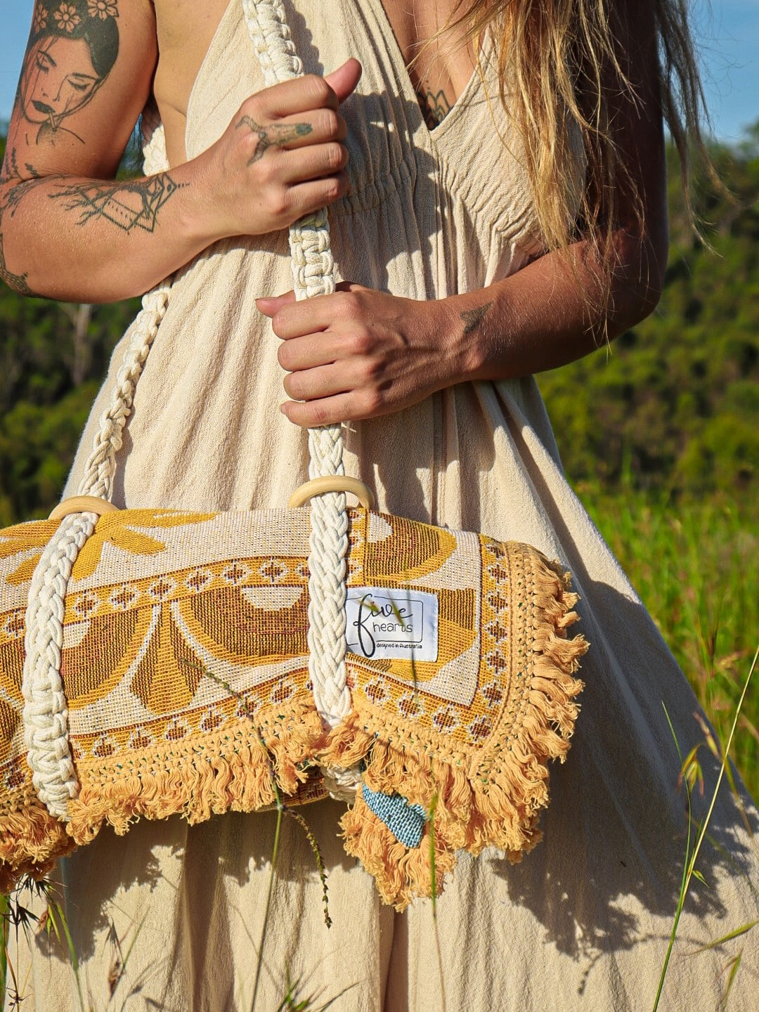Macramé carry strap wrapped around boho throw rug with palm design