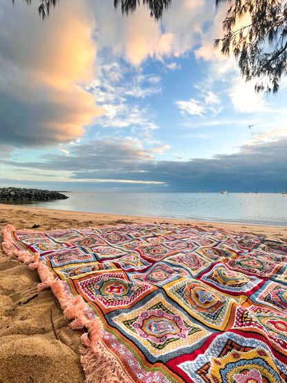 Forever Young Throw Rug laid on a beach overlooking the ocean at sunrise